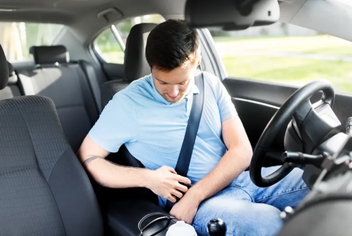 Driver latching the seat belt buckle at the side of the seat in a fleet vehicle
